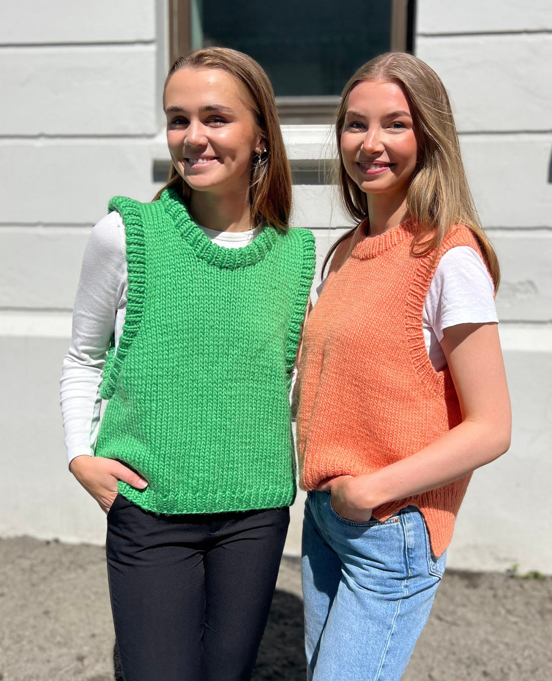 Two girls wearing knitted slipovers in green and peach orange yarn. The patterns are made in Dreamknit's design tool for knitters, where you make your personalized pattern in any yarn